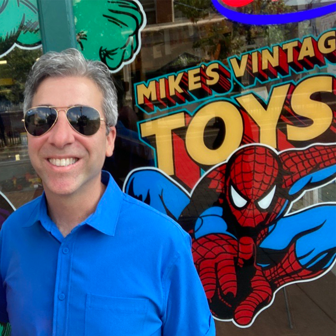 John Acquavita in front of the Mike's Vintage Toys window featuring Spiderman